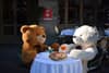 Two teddy bears enjoying pizza