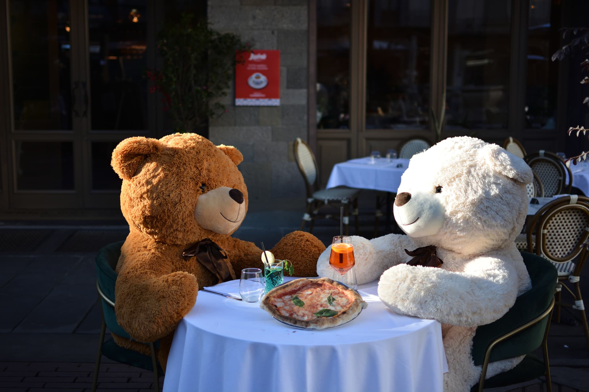 Two teddy bears enjoying pizza